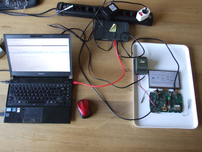 My rig to resuscitate toon: laptop with CentOS 6 + openembedded toolchain for toon, 100MBit router, 24V power supply, toon removed from housing, with serial connection to laptop.